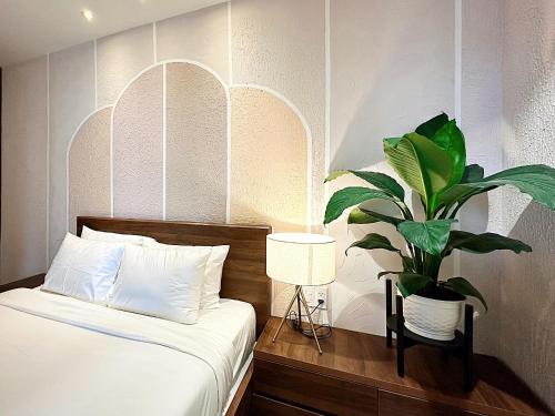 Un dormitorio con una cama y una planta en maceta. en Condo 2 Bedrooms Mountain view in Dalat Center Residence, en Da Lat