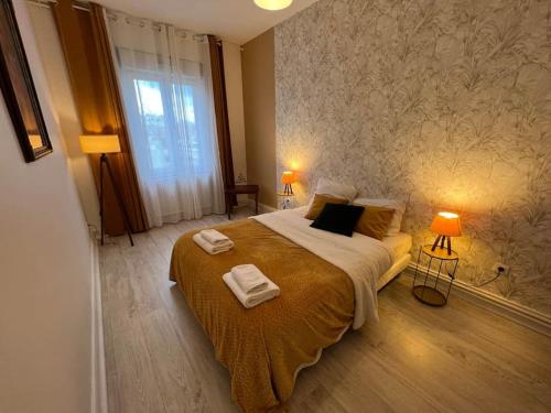 une chambre avec un grand lit avec des serviettes dessus dans l'établissement Esprit Mulhouse - 3 chambres de charme, à Mulhouse