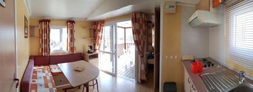 une chambre avec une table et une cuisine avec un balcon dans l'établissement Camping les Lacs d'Armagnac, à Bretagne-dʼArmagnac