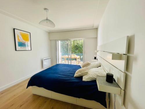 une chambre avec un grand lit avec une couverture bleue dans l'établissement Appartement La baule Le 30, à La Baule