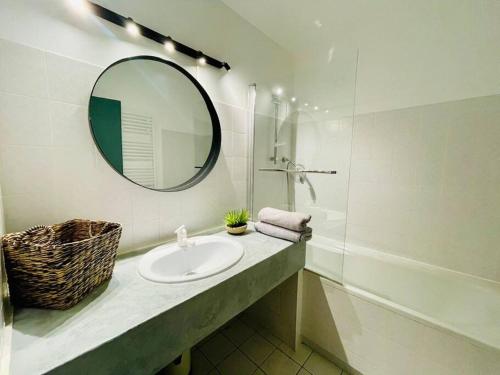 une salle de bain avec un lavabo et un miroir dans l'établissement Appartement La baule Le 30, à La Baule