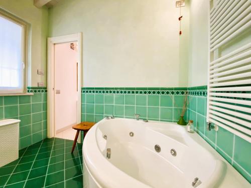 eine Badewanne in einem grün gefliesten Bad in der Unterkunft Villa Chiara in Polpenazze del Garda
