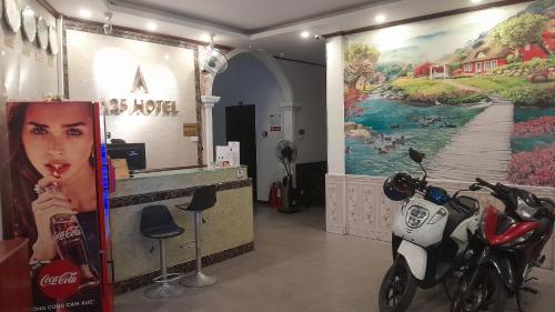 una moto aparcada en una habitación con una pintura en la pared en A25 Hotel - Đội Cấn 1, en Hanói