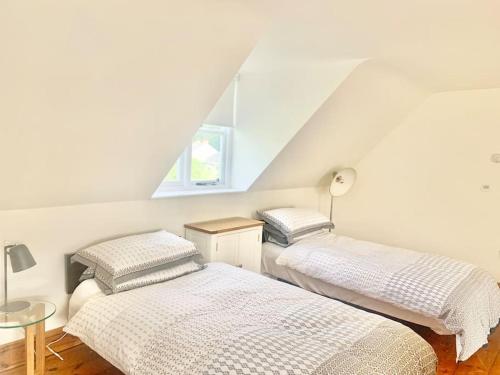two beds in a room with a attic at Delightful Ely house Bright and warm with cathedral view in Ely