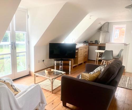 a living room with a couch and a tv at Delightful Ely house Bright and warm with cathedral view in Ely