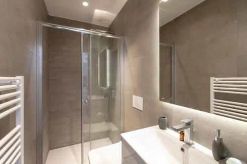 a bathroom with a glass shower and a sink at Superbe f1 au cœur du carré d’or terrasse/clim in Nice