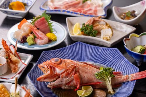 une table recouverte de plaques de nourriture avec un poisson dans l'établissement Kagariya, à Abashiri