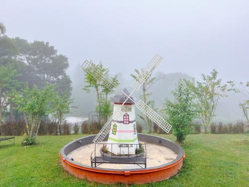 a small windmill in the middle of a field at เนริสารีสอร์ท เขาค้อ in Ban Khao Ya Nua
