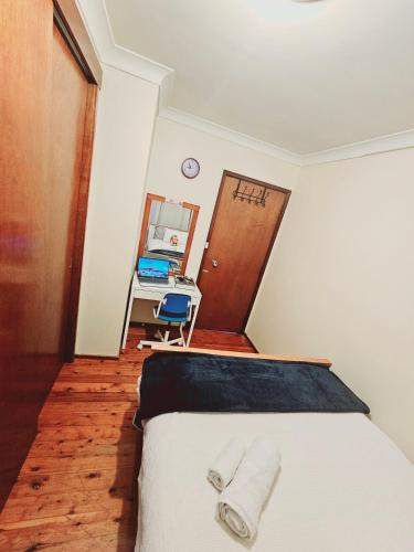 a bedroom with a bed with two towels on it at Kaban Power 7 in Doonside
