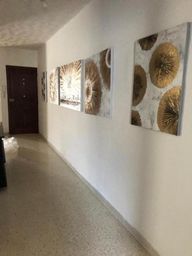 a room with three paintings on a wall at EEM Only Girls Student Residence in Is-Swieqi