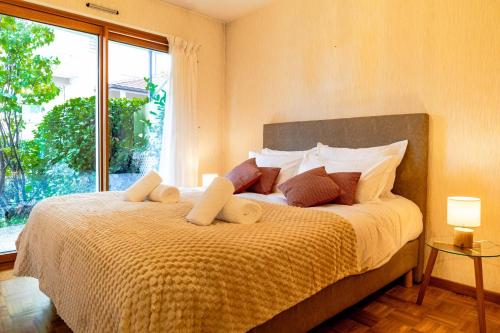 une chambre avec un grand lit avec une grande fenêtre dans l'établissement Le Gouverneur, 100m du lac avec parking, à Annecy