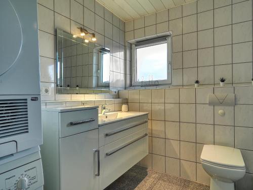 a bathroom with a sink and a toilet and a mirror at Ihr Zuhause fernab von Zuhause in Ringsheim