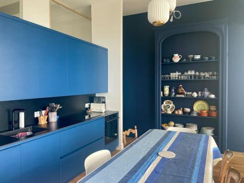 une cuisine bleue avec une table et un meuble bleu dans l'établissement FACE MER La Baule Le Panoramique, à La Baule