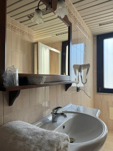 a bathroom with a sink and a large mirror at Hotel Vittoria in Rosarno