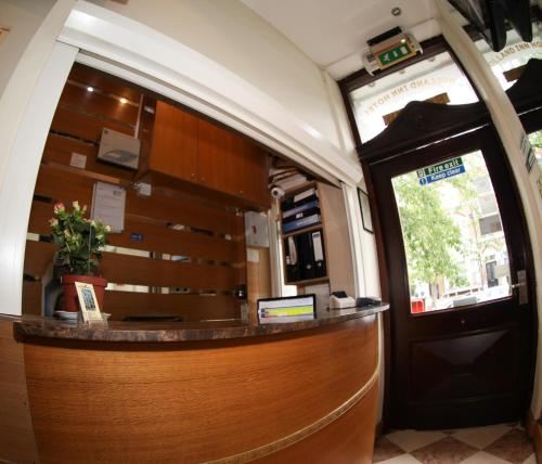 a lobby of a train with a counter and a door at Holland Inn Hotel in London