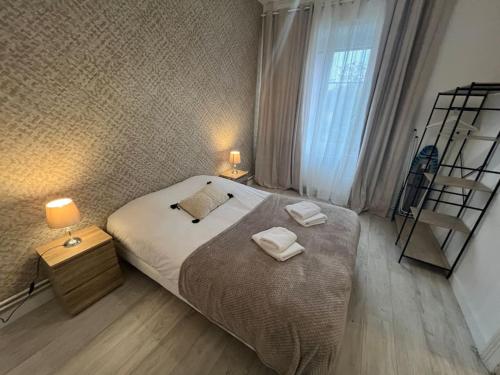 une chambre avec un grand lit avec deux serviettes dessus dans l'établissement Esprit Colmar - 2 chambres de charme, à Mulhouse