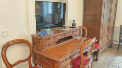 a wooden table with a television on top of it at A la Grenouille du Jura in Bellignat