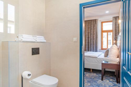 ein Bad mit einem WC und ein Schlafzimmer mit einem Bett in der Unterkunft Belvedere Spa & Kurhotel in Franzensbad