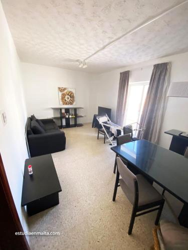 a living room with a table and chairs at EEM Only Girls Student Residence in Is-Swieqi