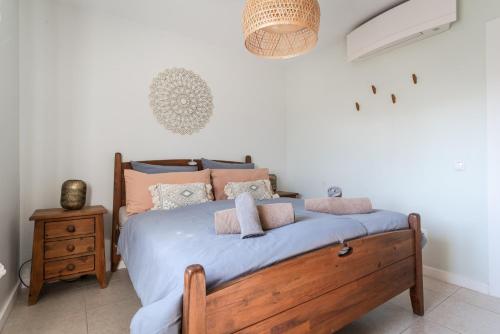 Schlafzimmer mit einem Bett mit blauer Bettwäsche und Kissen in der Unterkunft Aloha Apartment Arrifana in Arrifana Strand