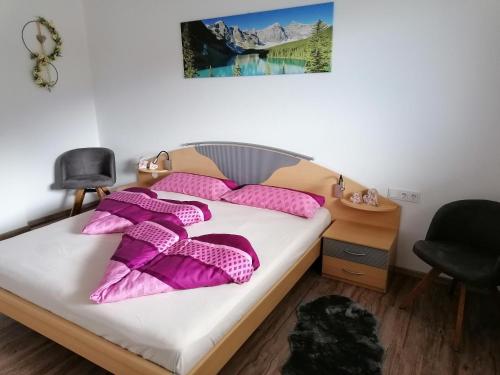 una camera da letto con letto e cuscini rosa di Zirlerhof a Weerberg