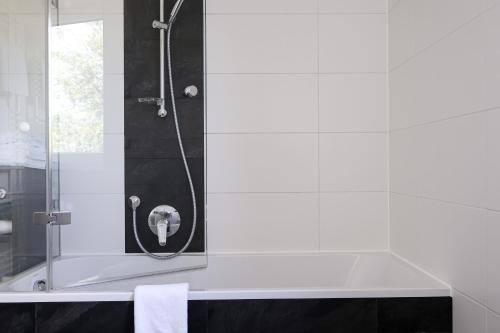 a bathroom with a shower with a bath tub at Ferienhaus Seezeichen in Wasserburg am Bodensee
