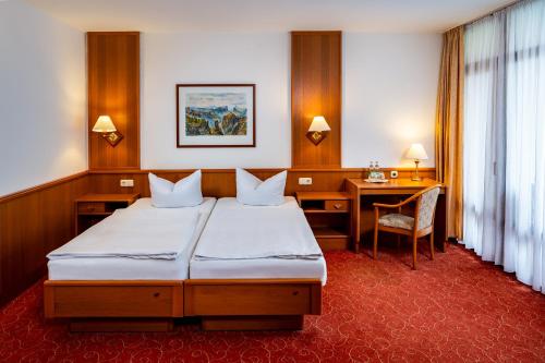 a hotel room with a bed and a desk at Hotel Zur Post in Pirna