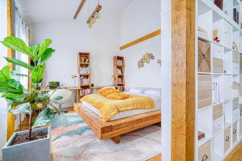 a bedroom with a bed and a potted plant at Greg & Theo's in Fontenay-sous-Bois