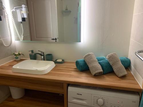 LE STUDIO DE DODA - Résidence de vacances - Sainte Anne في ساينت آن: منضدة الحمام مع الحوض والمرآة