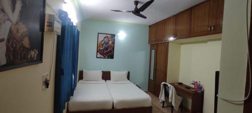 a bedroom with two beds and a ceiling fan at Greenapple Inn in Chennai