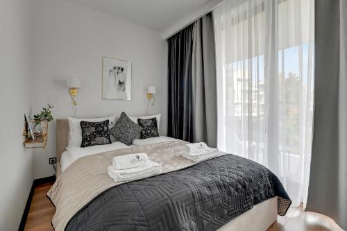 1 dormitorio con 1 cama con 2 toallas en Lion Apartments - New Helsinki Okrzei 19, en Sopot