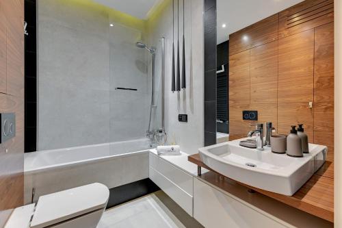 ソポトにあるNew Helsinki Luxury Residence Okrzei 19 by Lion Apartments Sopotの洗面台、トイレ、シャワー付きのバスルーム