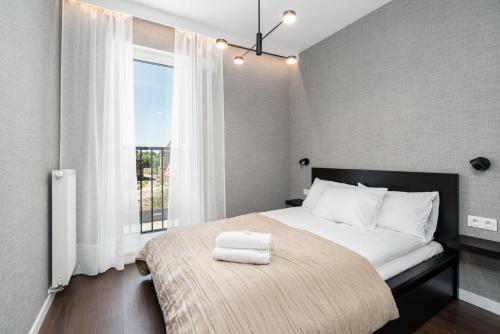 um quarto com uma cama e uma janela grande em Stylish & Comfy Garbary Apartments with Parking by Renters em Poznań