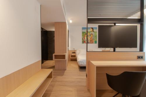 Habitación con TV y escritorio con silla. en Hotel Cortabitarte en Soria