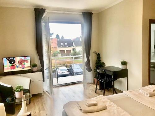 a bedroom with a bed and a table and a balcony at Fresh house in Prague