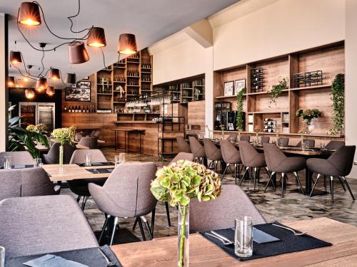 プシェジミエロボにあるHotel Edisonのテーブルと椅子のあるレストラン、バー