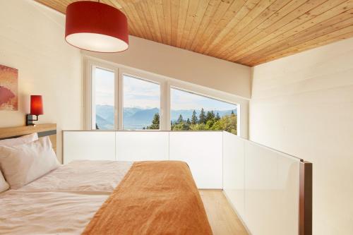 a bedroom with a bed and a large window at Rigi Kaltbad Swiss Quality Hotel in Rigi Kaltbad