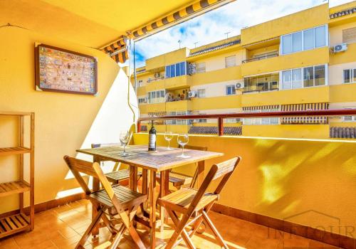 stół i krzesła na balkonie z budynkiem w obiekcie Inftour Apolo Apartamento w mieście Calpe