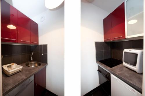 two different views of a kitchen with red cabinets at Résidence Le Crystal Dinard Plage in Dinard