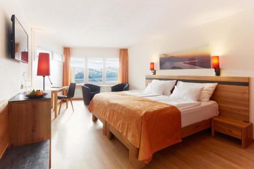 ein Hotelzimmer mit einem Bett und einem Schreibtisch in der Unterkunft Rigi Kaltbad Swiss Quality Hotel in Rigi Kaltbad