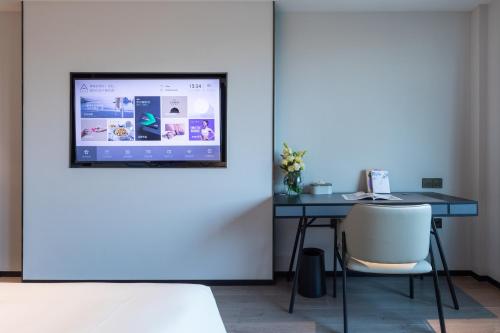 a room with a desk with a computer on the wall at Atour X Hotel Ningbo Railway Station Liuting Street in Ningbo