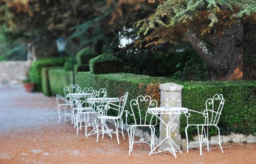 a row of tables and chairs in front of a hedge at Hotel Villa Casalecchi in Castellina in Chianti