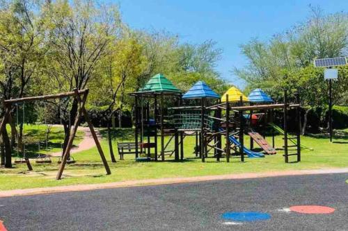 a park with a playground with slides and swings at Lustrous Loft Living in Penthouse in Roodepoort