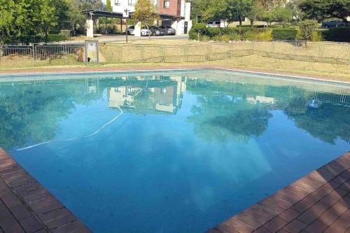 a swimming pool with blue water at Lustrous Loft Living in Penthouse in Roodepoort