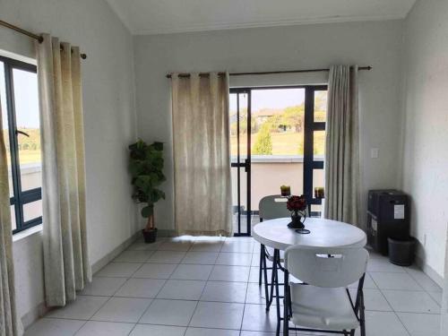 a living room with a table and chairs and a window at Lustrous Loft Living in Penthouse in Roodepoort