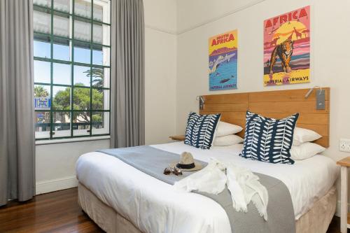 1 dormitorio con 1 cama grande con almohadas azules y blancas en Stone Cottages, en Ciudad del Cabo