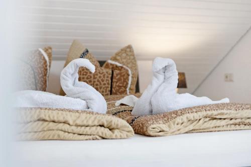 a pile of towels and blankets on a bed at Ferienwohnungen Lilie Und Dahlie in Münsingen