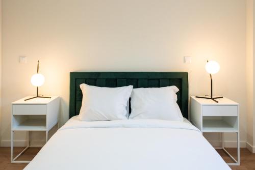 ein Schlafzimmer mit zwei Nachttischen und einem Bett mit zwei Lampen in der Unterkunft Pardal RC A - Luxury 2 Bed Apartment in Alcantara in Lissabon