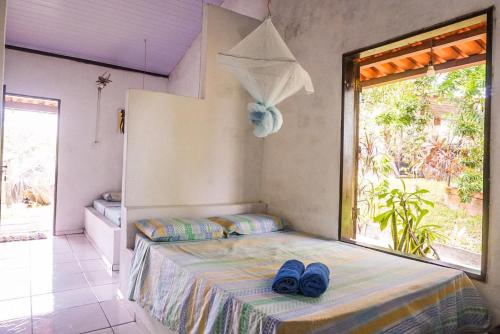 um quarto com uma cama com sapatos azuis em Pousada Mirage Atins em Atins