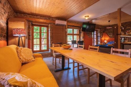 a dining room with a wooden table and a couch at The Pirates Lodge Milina - Chill-out in Strandnähe in Milína